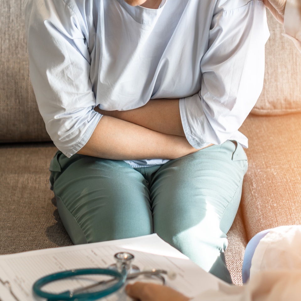 Abdominal pain patient woman having medical exam with doctor on illness from stomach cancer, irritable bowel syndrome, pelvic discomfort, Indigestion, Diarrhea, GERD (gastro-esophageal reflux disease)