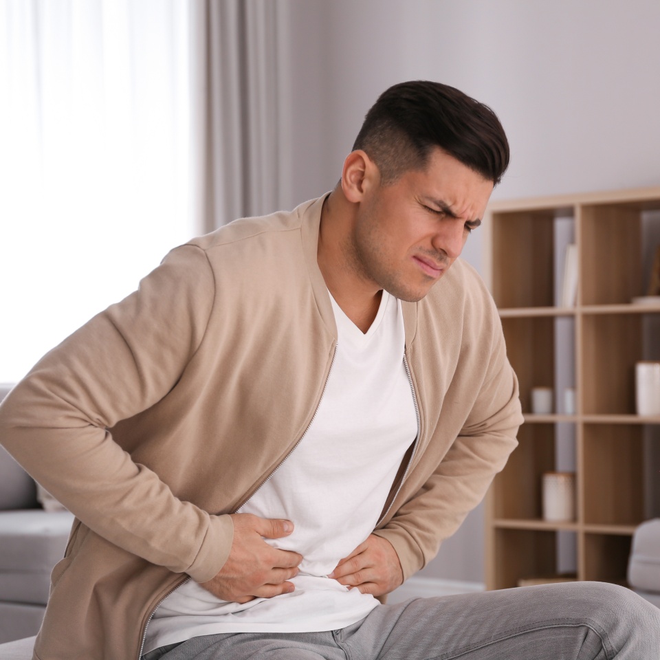 Man suffering from stomach ache at home. Food poisoning