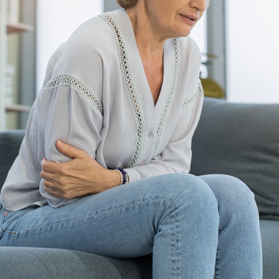 Flatulence caucasian mature adult, senior woman hand in stomach ache, suffer from food poisoning, abdominal pain and colon problem, gastritis or diarrhoea. Patient belly, abdomen or inflammation.