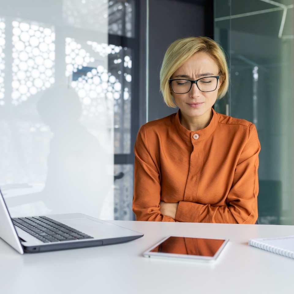 Sick woman alone at workplace has severe stomach pain, businesswoman food poisoning has heartburn and diarrhea inside office.