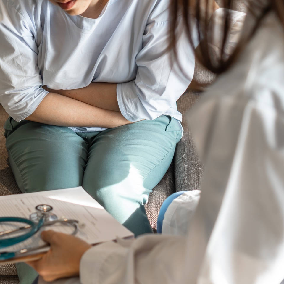 Abdominal pain patient woman having medical exam with doctor on illness from stomach cancer, irritable bowel syndrome, pelvic discomfort, Indigestion, Diarrhea, GERD (gastro-esophageal reflux disease)