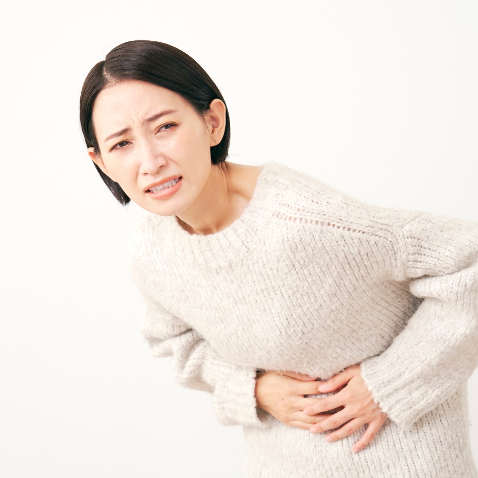 Asian middle aged woman having a stomachache in white background