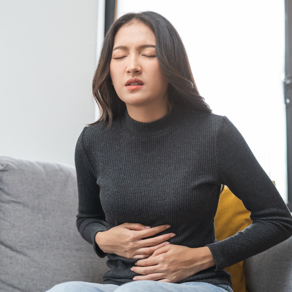 Flatulence asian young woman, girl hand in stomach ache, suffer from food poisoning, abdominal pain and colon problem, gastritis or diarrhoea. Patient belly, abdomen or inflammation, concept.