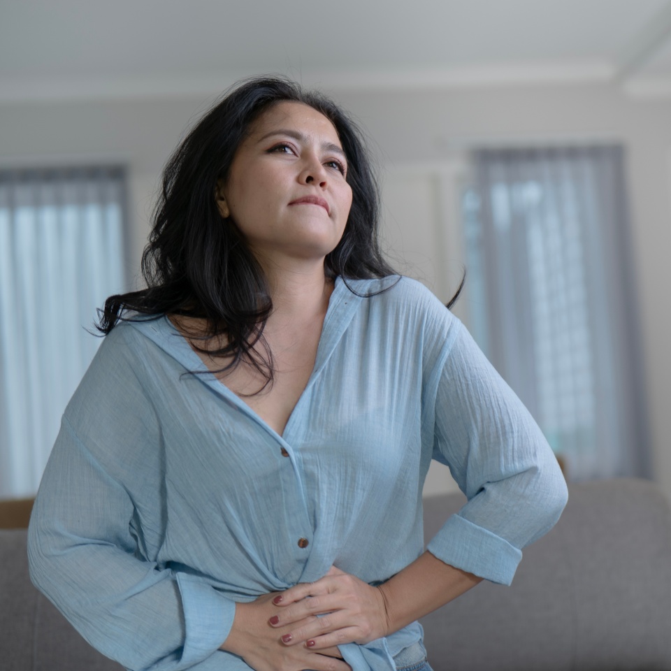 Asian women having monthlies menstruation and Severe stomach pains in the living room feel the pain wearing a blue shirt