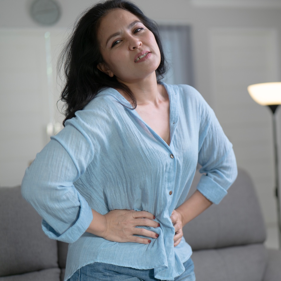 Asian women having monthlies menstruation and Severe stomach pains in the living room feel the pain wearing a blue shirt