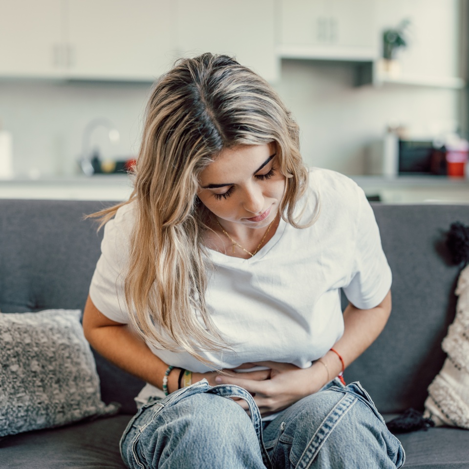 Sick young woman in pain holding belly stomach feeling hurt abdomen ache gastritis pancreatitis symptoms or diarrhea, upset teen girl suffering from indigestion flatulence abdominal problem concept