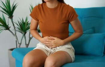 Irritable bowel syndrome. Young woman holds the lower part of the abdomen due to sudden pain.