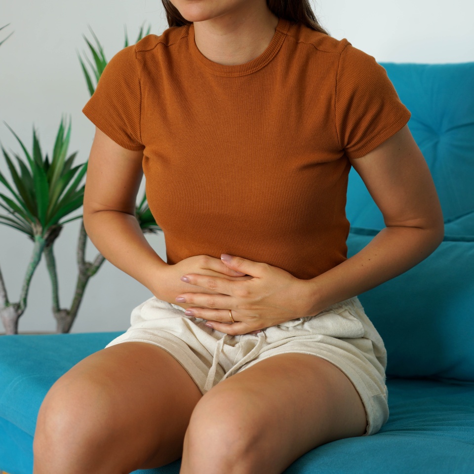 Irritable bowel syndrome. Young woman holds the lower part of the abdomen due to sudden pain.