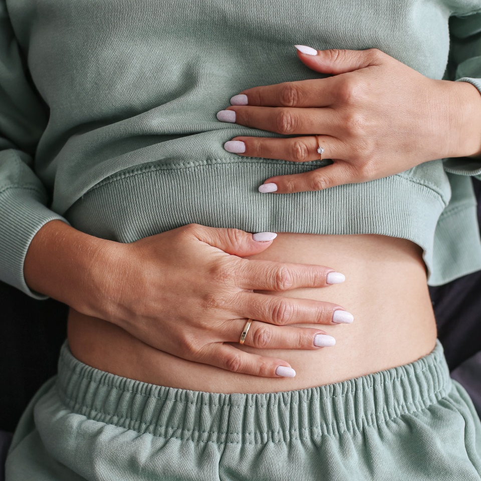 Woman holding stomach. Stomach pain and discomfort. Digestive health problem. Indigestion and bloating. Medical issue with abdomen. Healthcare and lifestyle. Symptoms of poor digestion.