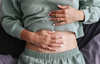 Woman holding stomach. Stomach pain and discomfort. Digestive health problem. Indigestion and bloating. Medical issue with abdomen. Healthcare and lifestyle. Symptoms of poor digestion.